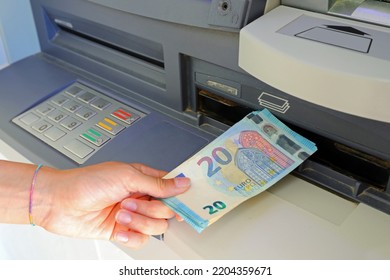 hand picking up money in European banknotes from an ATM bank cash machine in Europe - Shutterstock ID 2204359671
