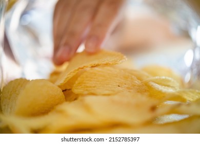 Hand Picking Potato Chips Inside Snack Bag