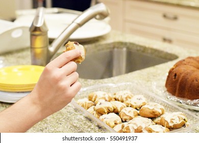 Hand Picking Up Pumpkin Cookie From Plate At Family Holiday Gathering (Thanksgiving)