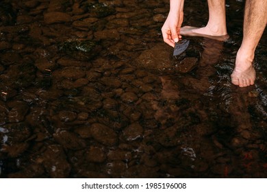 Hand Picking Up Stones And Rocks In A Riverbed