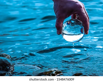 Hand Picking Up Water Ball From The Bow River