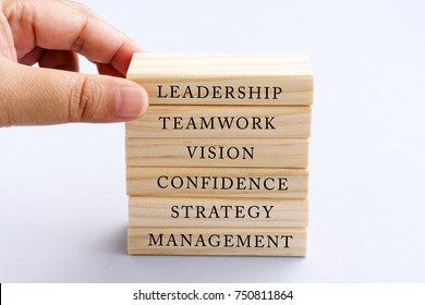 Hand Picking Wood Block with Word Leadership. Business Concept - Wood Top Block with Word: Leadership, Teamwork, Vision, Confidence, Strategy and Management.   