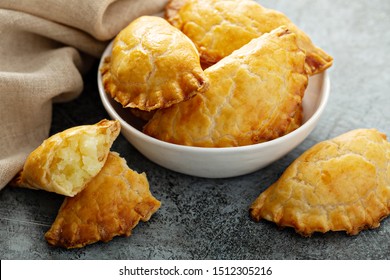 Hand pies, pasties, samosas or pierogies with potato filling golden baked