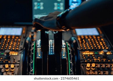 Hand of a pilot on the power levers of an airliner