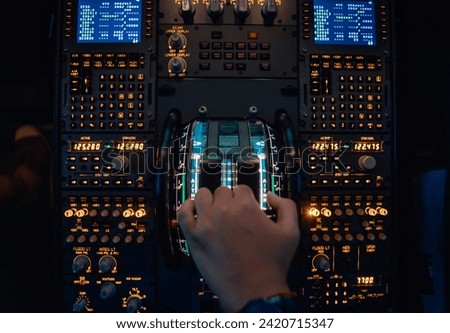 Hand of a pilot at the thrust levers of a jet