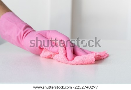 a hand in a pink glove wipes the surface with pink microfiber. High quality photo Imagine de stoc © 