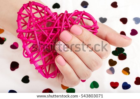 Hand with pink matte manicured nails holding a heart Stock foto © 