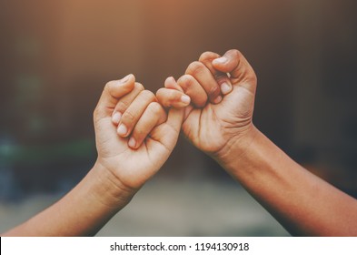 Hand to pinky swear,Happy couple or friendship holding hands together forever love concept. - Shutterstock ID 1194130918