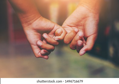 Hand to pinky swear,Happy couple or friendship holding hands together forever love concept. - Shutterstock ID 1496716679