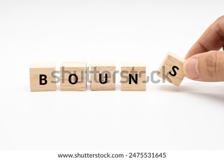 Hand place wooden cube blocks with BONUS text isolated on white background. Bonus wage for holidays. Benefit, cash back. Business concept