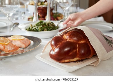 Hand Placing Dish On Table Set For Jewish Shabbat, Close Up