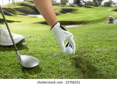 Hand Placing A Golf Ball On Tee