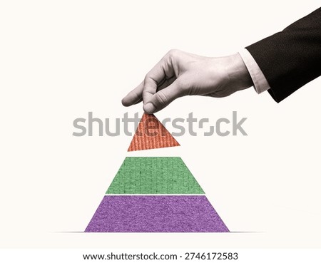 Hand placing the top element on a colorful pyramid. Concept of business growth, strategy, hierarchy, leadership, planning, success, teamwork, and structured development.