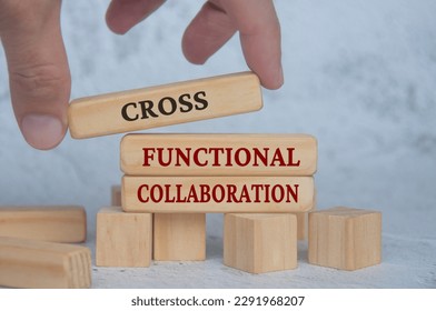Hand placing wooden blocks with cross functional collaboration text on wooden blocks. Operational excellence and business concept.