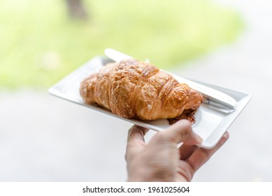 A hand with a plate of bread
