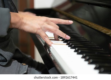 Hand playing electric keyboard piano keys
