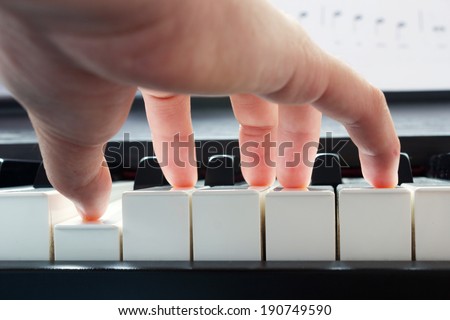 Hand playing piano taken from low angle point