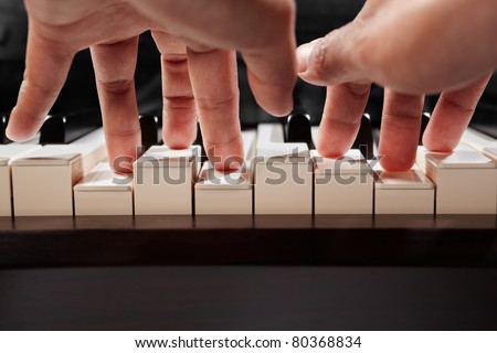 Hand playing piano taken from low angle point