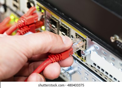 Hand Plugging Network Cable Into Switch In Datacenter