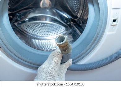 Hand Of A Plumber Holding A Broken Flexible Drain Hose Of Washing Machine, Clogged And Covered With Lime Scale, Dirt Limescale And Rust.