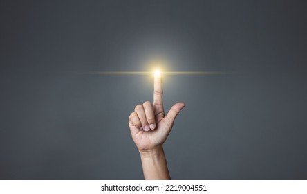 Hand pointing to an empty area on a dark background. - Powered by Shutterstock