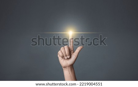 Hand pointing to an empty area on a dark background.
