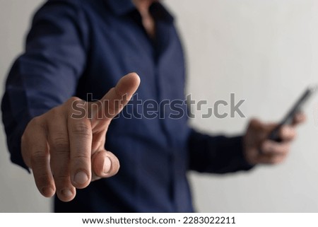 Hand pointing finger touching blank virtual screen, modern business background concept can be used for montage your text or photo on finger