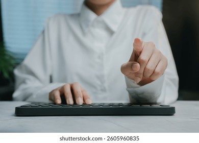 A Hand pointing at keyboard in modern office setting, Business concept