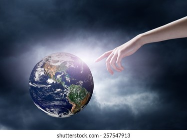 hand pointing at planet in space. Elements of this image are furnished by NASA