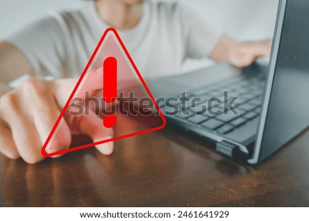 Hand pointing to Red triangle caution sign or attention sign and use laptop for work or business concept for Cybersecurity Awareness,Risk and Vulnerability,Warning and Caution,Attention and Alertness.