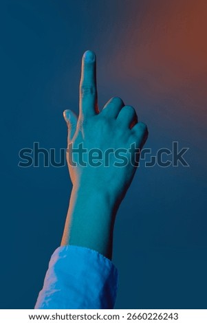 Hand pointing upward under dramatic blue and orange lighting. Concept of biometric access, secure interface design, digital banking UX, fintech verification.