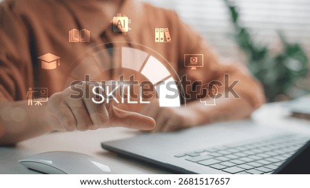 Hand pointing at virtual skill development icon on laptop screen, symbolizing online learning, digital training, reskilling, upskilling, education technology, and professional career growth.