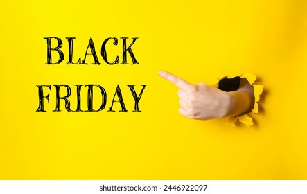 A hand pointing to a yellow background with the words Black Friday written in black. Concept of excitement and anticipation for the upcoming holiday shopping season - Powered by Shutterstock