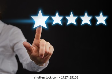 The Hand Points To Five 5 Stars As A Concept Of Top Rating Or Rating. Close Up.