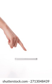 Hand points at a flat object on a white surface with focus on a finger touching the item