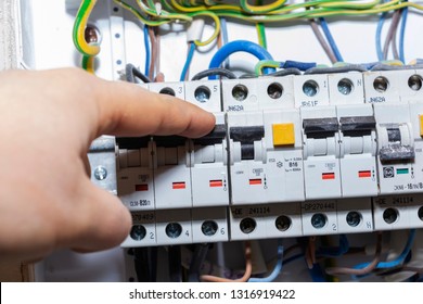 The Hand Points To A Fuse In The Power Meter. The Man Disables The Current Fuses, The Safety Concept Of The Power Suppression, And The Protection Of Electrical Devices