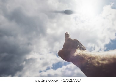 Hand points to the UFO in the sky. The day of the UFO concept of a conspiracy - Shutterstock ID 1728277087