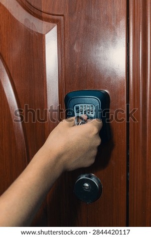 Hand is positioned to input a code on a digital keypad lock attached to a wooden door, highlighting security technology in a home environment
