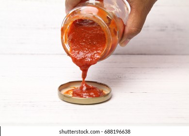 Hand Pour Delicious Homemade Classic Spicy Tomato Pasta Or Pizza Sauce Over Wooden Texture Background. Selective Focus