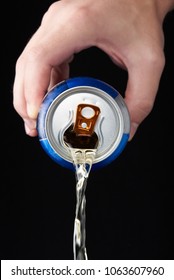 Hand Pouring Beer From Metal Can Isolated On Black Background