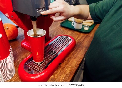 Hand Pouring Cola In Red Cup. Stylish Soda Machine On Wooden Desk. Take To Go. Catering In Food Court At Mall Concept. Space For Text. Modern Kitchen