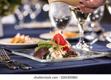 Hand Pouring Dressing On Salad