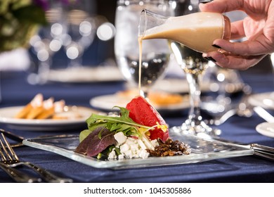 Hand Pouring Dressing On Salad