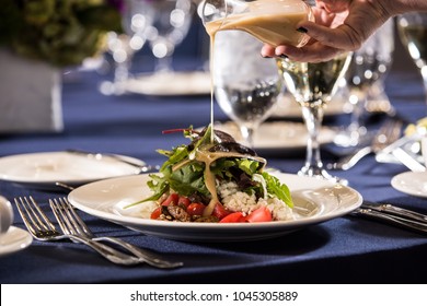 Hand Pouring Dressing On Salad