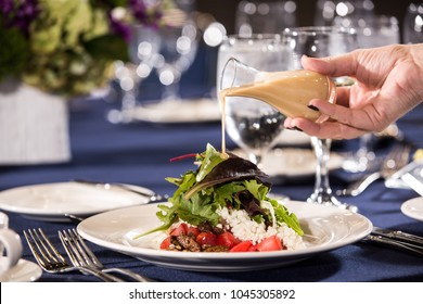 Hand Pouring Dressing On Salad