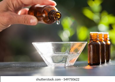 hand pouring essential oil in a bowl - Shutterstock ID 549750622