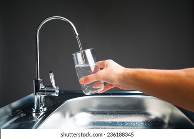 Hand Pouring A Glass Of Water From Filter Tap