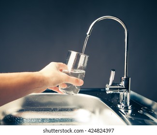 Hand Pouring A Glass Of Water From Filter Tap