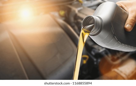 Hand Pouring oil to car engine, Fresh oil poured during an oil change to a car.