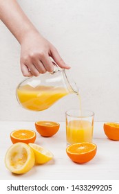 Hand Pouring Orange Juice In Glass